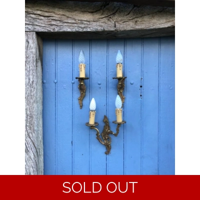 A trio of fine old French wall sconces lamps in a mix of brass/cast bronze in a rococo style: one two-lamp and two single-lamp wall sconces